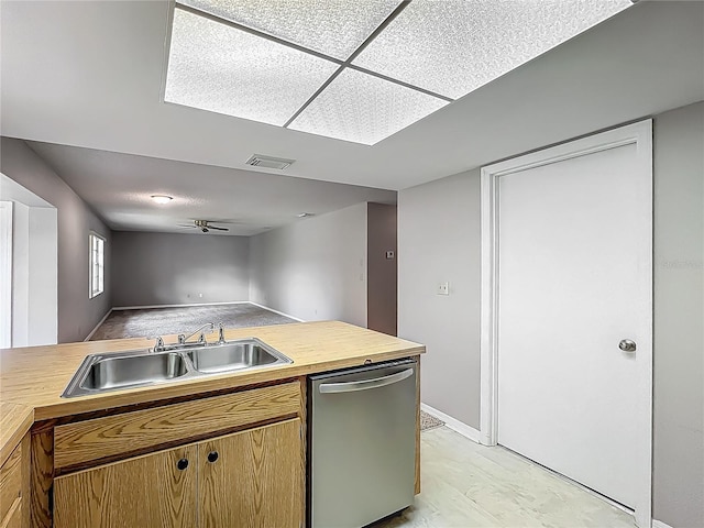 kitchen featuring stainless steel dishwasher, a sink, butcher block countertops, open floor plan, and baseboards