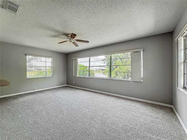 unfurnished room with a ceiling fan, carpet flooring, a textured ceiling, and baseboards