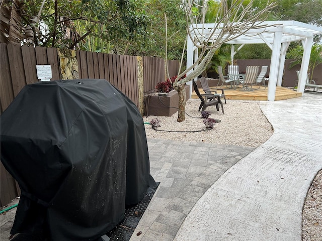 8240 144th Ln, Seminole, FL 33776 - fenced backyard featuring a grill, a wooden deck, and a patio area
