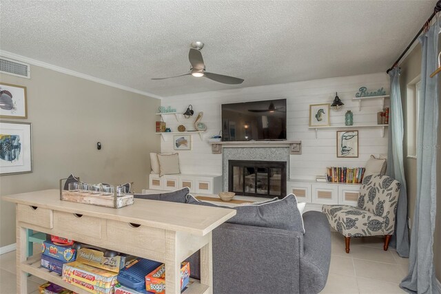 8240 144th Ln, Seminole, FL 33776 - living area featuring a ceiling fan, a textured ceiling, crown molding, a glass covered fireplace, and light tile patterned flooring