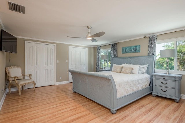 8240 144th Ln, Seminole, FL 33776 - bedroom with multiple closets, light wood-style flooring, crown molding, baseboards, and ceiling fan
