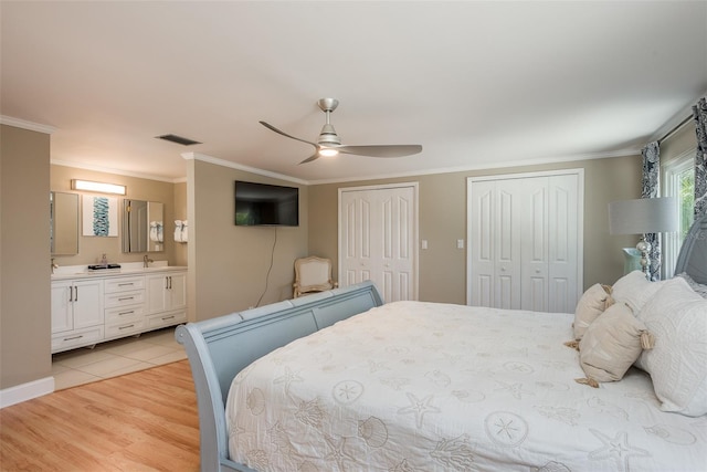 8240 144th Ln, Seminole, FL 33776 - bedroom with multiple closets, crown molding, light wood-type flooring, connected bathroom, and ceiling fan