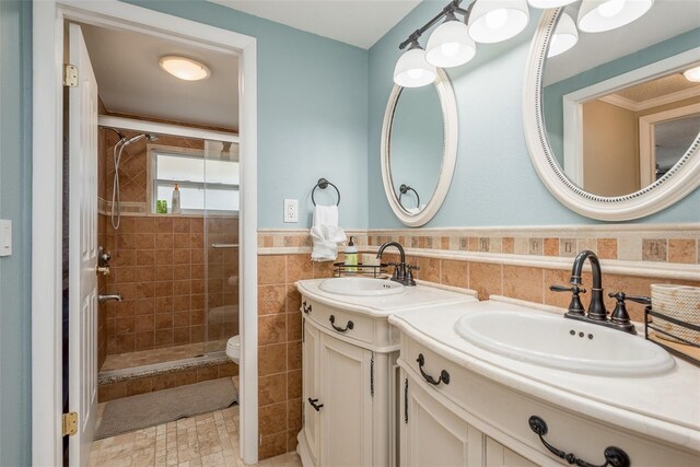 8240 144th Ln, Seminole, FL 33776 - bathroom featuring a stall shower, double vanity, wainscoting, tile walls, and toilet