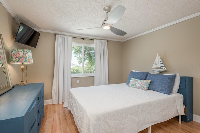 8240 144th Ln, Seminole, FL 33776 - bedroom with light wood finished floors, a textured ceiling, baseboards, crown molding, and a ceiling fan