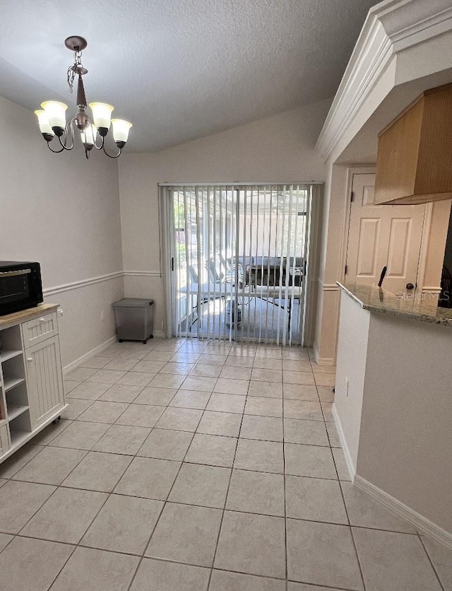 2528 Deerbrook Dr, Lakeland, FL 33811 - unfurnished dining area featuring light tile patterned floors, a chandelier, a textured ceiling, lofted ceiling, and baseboards