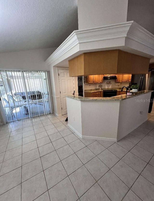 2528 Deerbrook Dr, Lakeland, FL 33811 - kitchen with light tile patterned floors, electric range, under cabinet range hood, a textured ceiling, and a peninsula