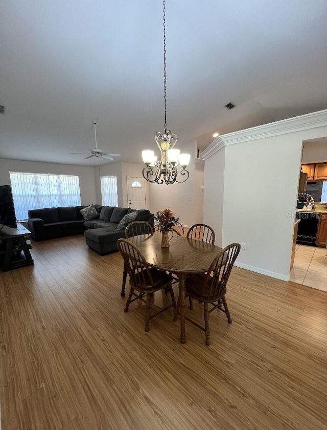 2528 Deerbrook Dr, Lakeland, FL 33811 - dining area featuring light wood-type flooring, a chandelier, ceiling fan, ornamental molding, and baseboards