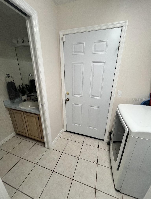 2528 Deerbrook Dr, Lakeland, FL 33811 - washroom with washer / dryer, light tile patterned floors, and baseboards