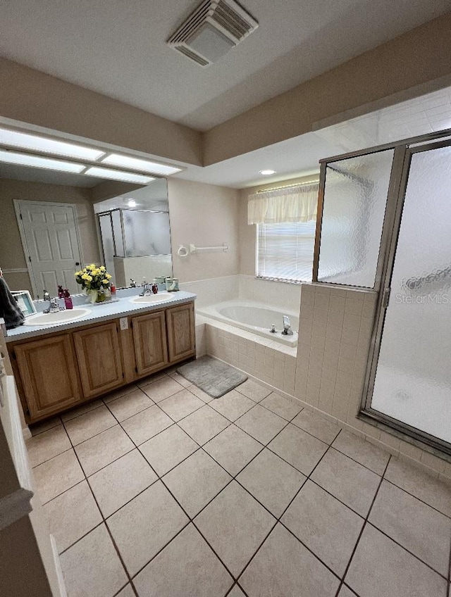 2528 Deerbrook Dr, Lakeland, FL 33811 - bathroom featuring tile patterned floors, a bath, a stall shower, and double vanity