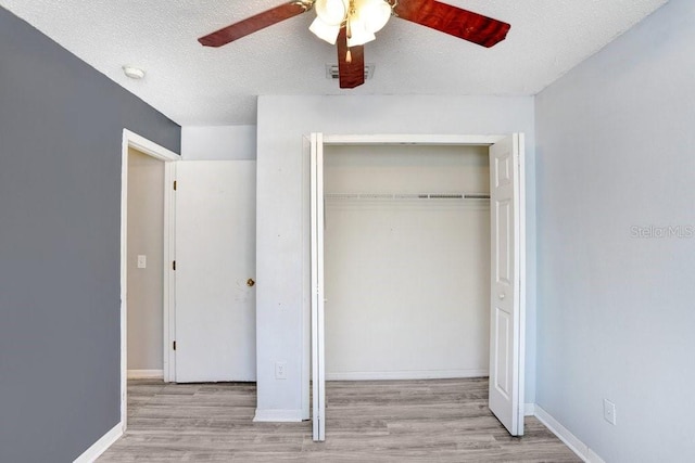 13523 Prestwick Dr, Riverview, FL 33579 - unfurnished bedroom with a closet, wood finished floors, a ceiling fan, baseboards, and a textured ceiling