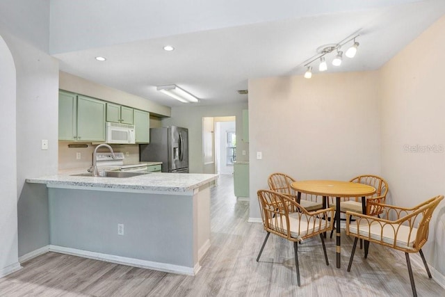 13523 Prestwick Dr, Riverview, FL 33579 - kitchen featuring green cabinets, white appliances, a sink, light wood finished floors, and recessed lighting