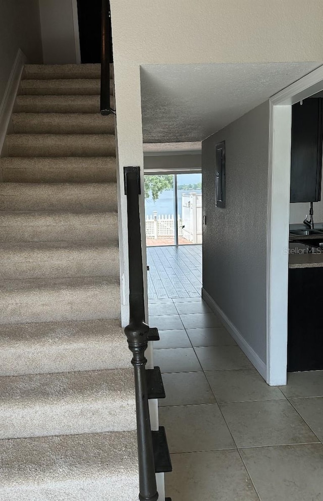 2557 Cedar Cypress Ct, Tampa, FL 33618 - stairs with tile patterned flooring and a textured ceiling
