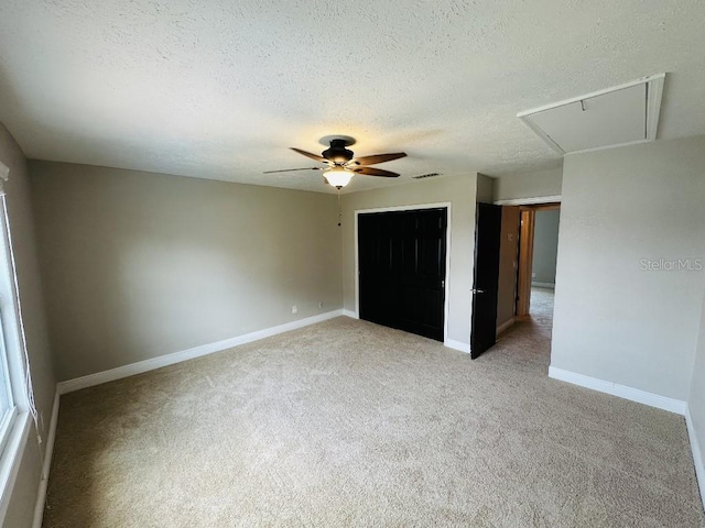 2557 Cedar Cypress Ct, Tampa, FL 33618 - unfurnished bedroom with attic access, a textured ceiling, light carpet, a closet, and ceiling fan