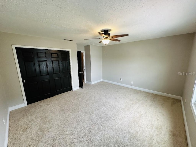 2557 Cedar Cypress Ct, Tampa, FL 33618 - unfurnished bedroom featuring carpet floors, a closet, a textured ceiling, and ceiling fan