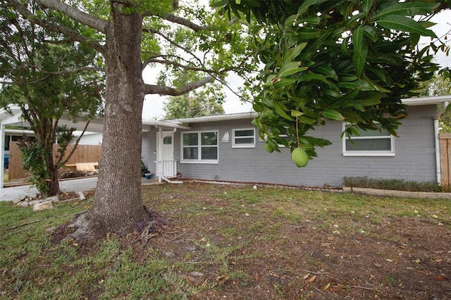 view of front facade featuring fence and concrete block siding