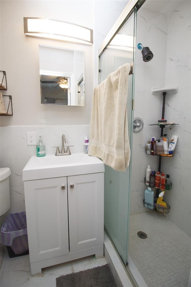 full bath featuring a shower stall, marble finish flooring, vanity, and toilet