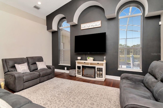 living room featuring dark wood-type flooring, baseboards, and recessed lighting