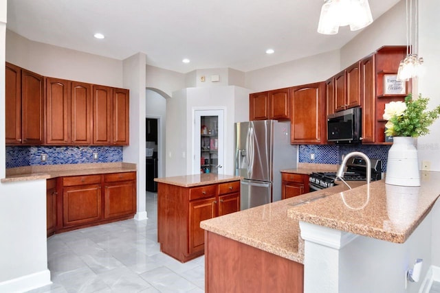 kitchen featuring appliances with stainless steel finishes, arched walkways, decorative backsplash, light stone counters, and recessed lighting