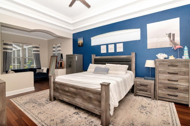 bedroom featuring wood finished floors, crown molding, a tray ceiling, and ceiling fan
