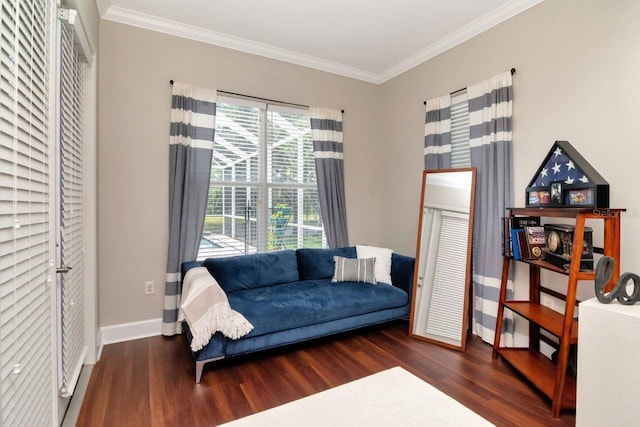 sitting room with wood finished floors, ornamental molding, and baseboards