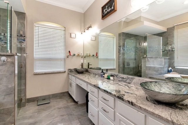 bathroom with baseboards, ornamental molding, a stall shower, and double vanity
