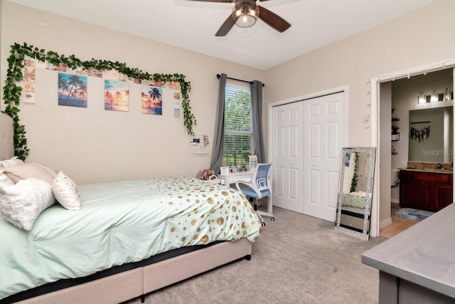 bedroom with light colored carpet, a closet, connected bathroom, and a ceiling fan
