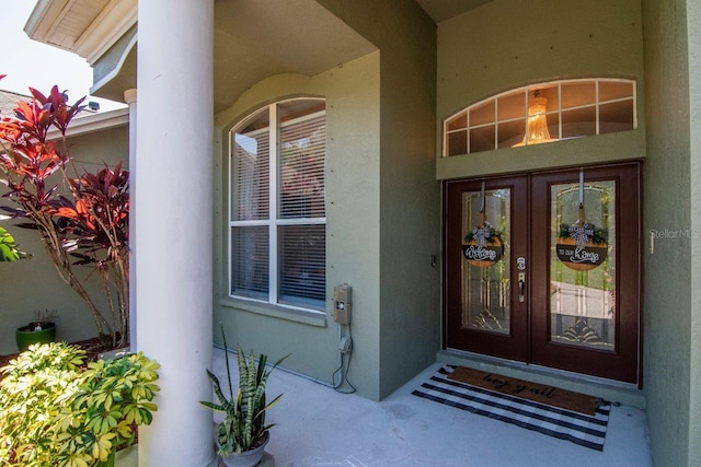 view of exterior entry with stucco siding and french doors