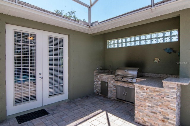 view of patio / terrace featuring french doors, area for grilling, exterior kitchen, and a sink