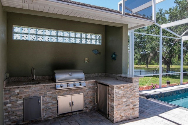 view of patio featuring a sink, area for grilling, a grill, and a lanai