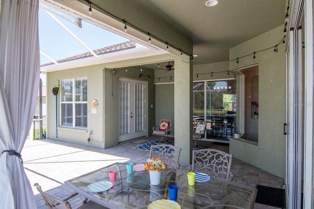 view of patio / terrace featuring a lanai, french doors, ceiling fan, and outdoor dining area