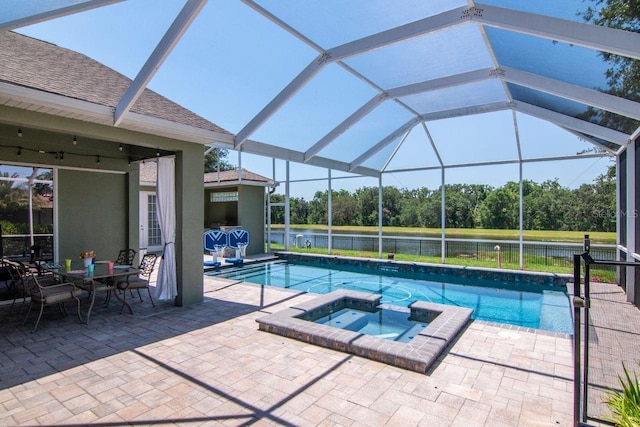 view of swimming pool with view of scattered trees, a patio, a water view, a pool with connected hot tub, and glass enclosure
