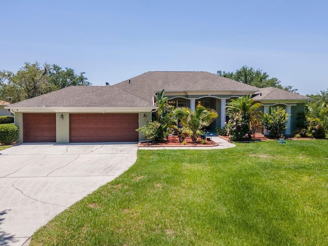ranch-style home featuring a garage, a front yard, concrete driveway, a shingled roof, and stucco siding