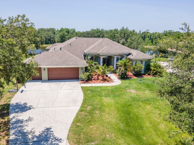 view of front of property featuring an attached garage, driveway, a front yard, and a shingled roof