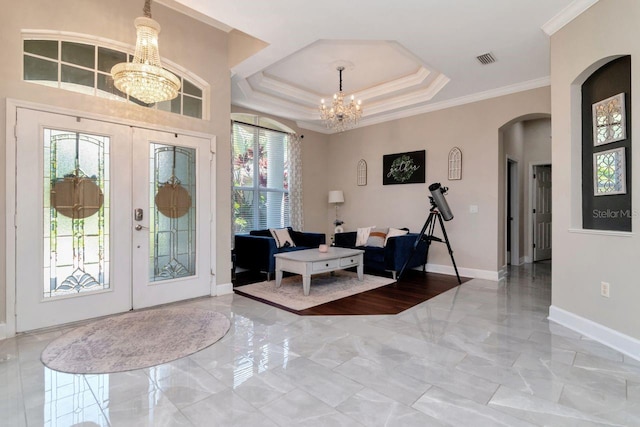 foyer with a chandelier, marble tiled floors, french doors, crown molding, and baseboards