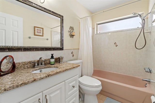 bathroom with toilet, shower / bath combo with shower curtain, vanity, tile patterned floors, and tile walls