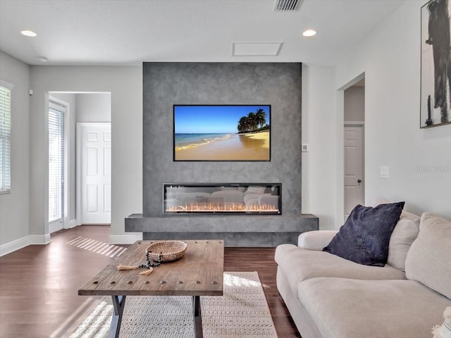 living room featuring wood finished floors, a fireplace, baseboards, and recessed lighting