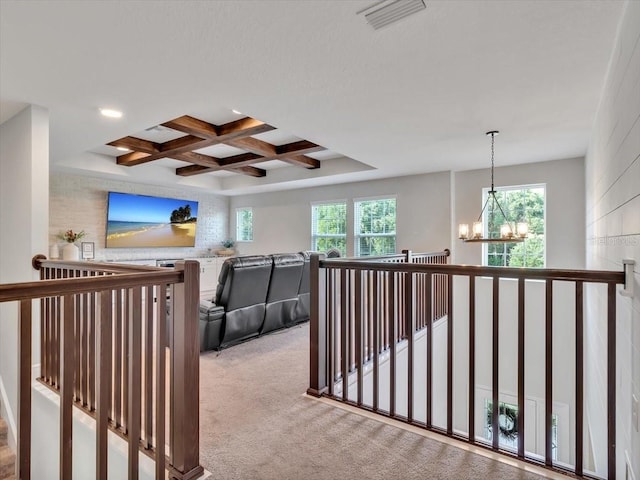 hall with an upstairs landing, a chandelier, carpet flooring, coffered ceiling, and beamed ceiling