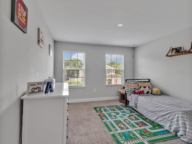bedroom featuring light colored carpet and baseboards