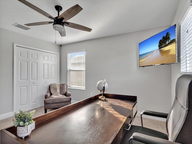carpeted office featuring baseboards, ceiling fan, and healthy amount of natural light