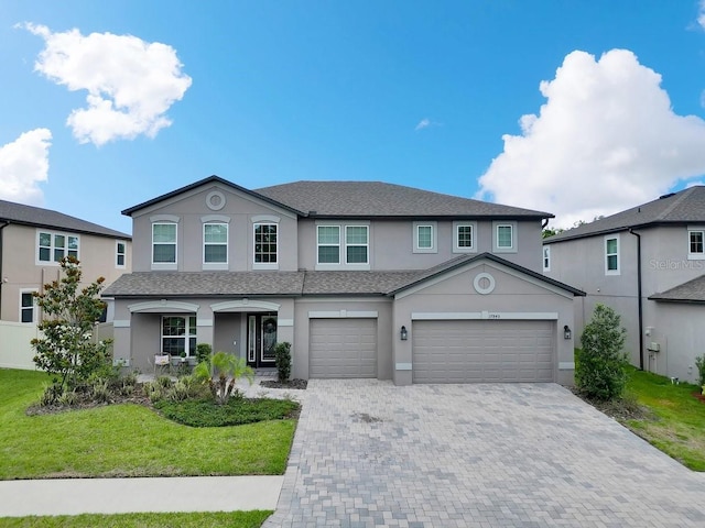 17845 Cortes Creek Blvd, Spring Hill, FL 34610 - view of front of home featuring stucco siding, decorative driveway, a front yard, and a garage