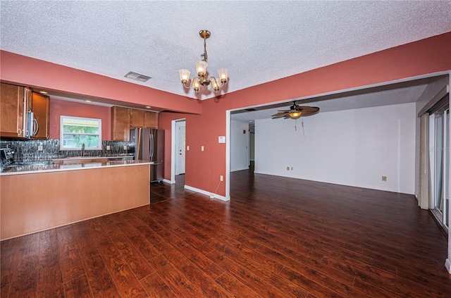 10051 82nd Ln, Seminole, FL 33777 - kitchen featuring stainless steel appliances, open floor plan, brown cabinets, a chandelier, and a peninsula