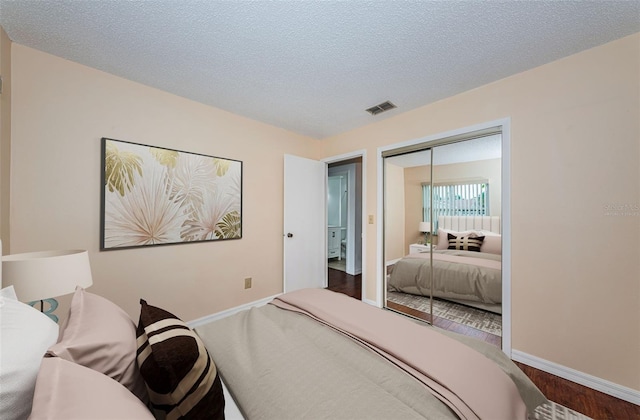 10051 82nd Ln, Seminole, FL 33777 - bedroom featuring baseboards, wood finished floors, a closet, and a textured ceiling