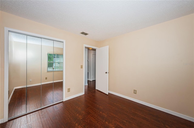 10051 82nd Ln, Seminole, FL 33777 - unfurnished bedroom featuring wood-type flooring, baseboards, a closet, and a textured ceiling