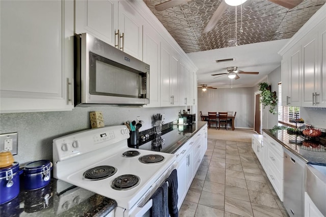 1716 Bayou Cir, Lakeland, FL 33803 - kitchen featuring appliances with stainless steel finishes, ceiling fan, white cabinetry, dark countertops, and an ornate ceiling