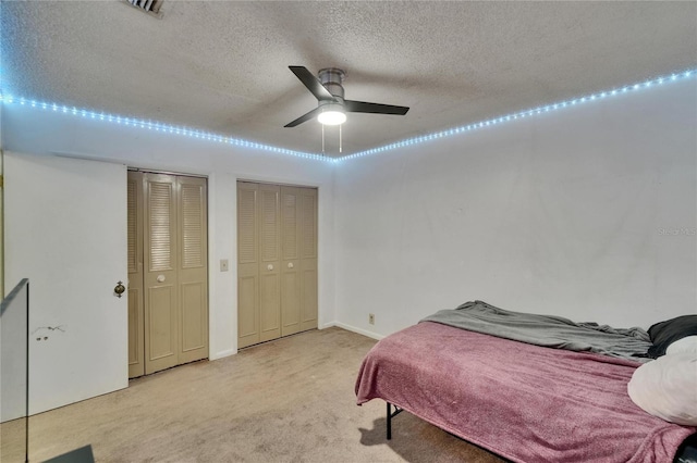 1716 Bayou Cir, Lakeland, FL 33803 - bedroom with carpet floors, two closets, a textured ceiling, ceiling fan, and baseboards