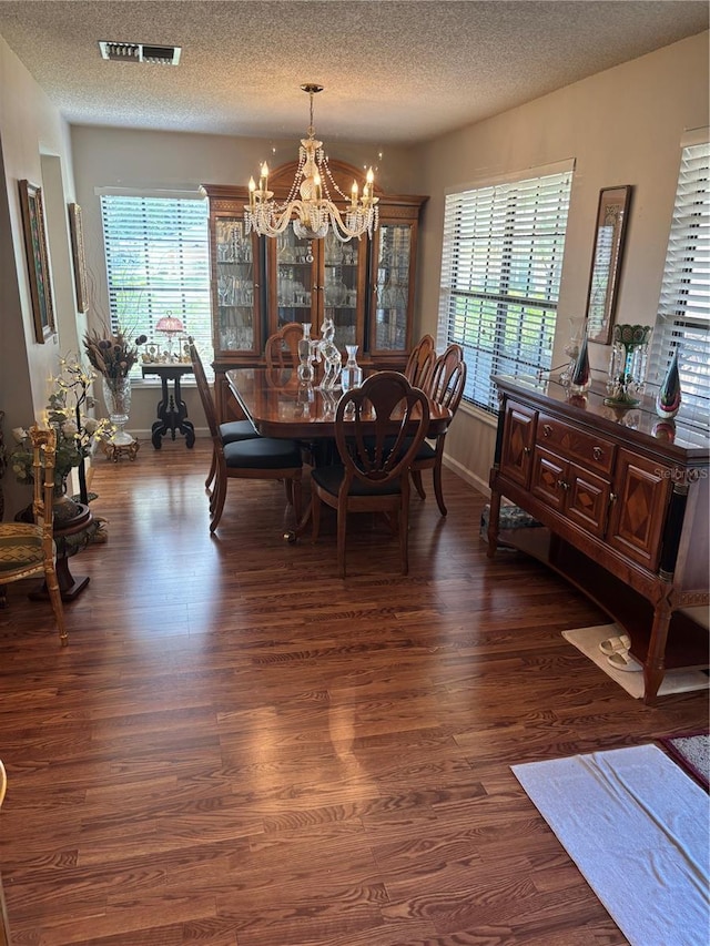 9302 Trowbridge Ct, New Port Richey, FL 34655 - dining area featuring a chandelier, healthy amount of natural light, dark wood-type flooring, and a textured ceiling