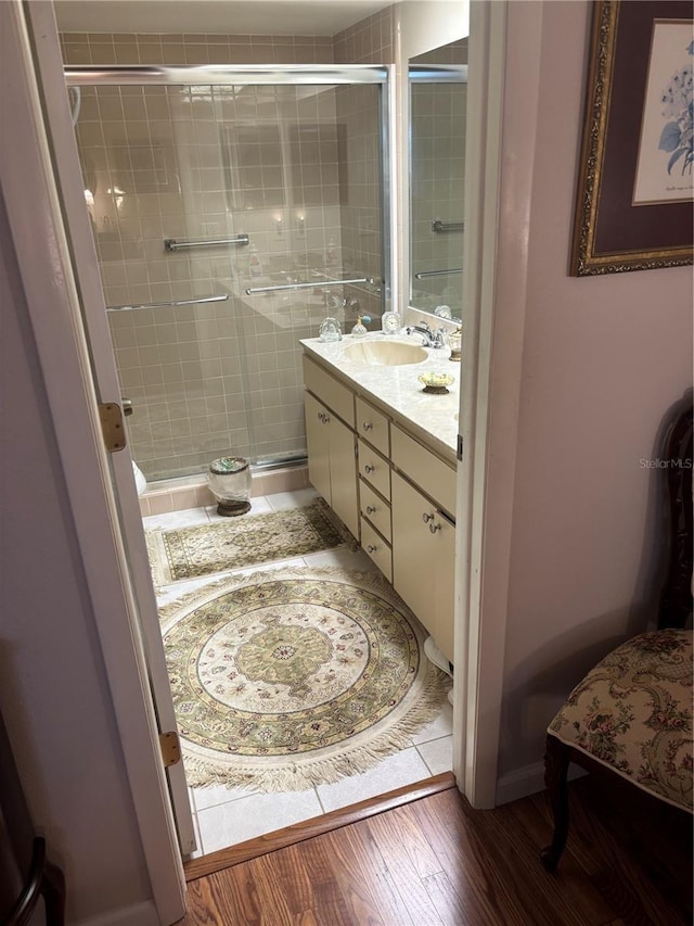 9302 Trowbridge Ct, New Port Richey, FL 34655 - bathroom with vanity, a stall shower, and wood finished floors