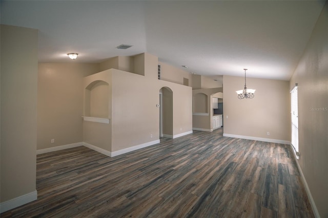 19247 Otters Wick Way, Land O Lakes, FL 34638 - empty room with a chandelier, dark wood-style floors, lofted ceiling, baseboards, and arched walkways