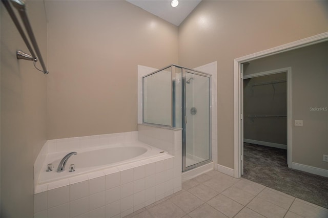 19247 Otters Wick Way, Land O Lakes, FL 34638 - bathroom featuring a stall shower, a bath, a spacious closet, tile patterned floors, and baseboards