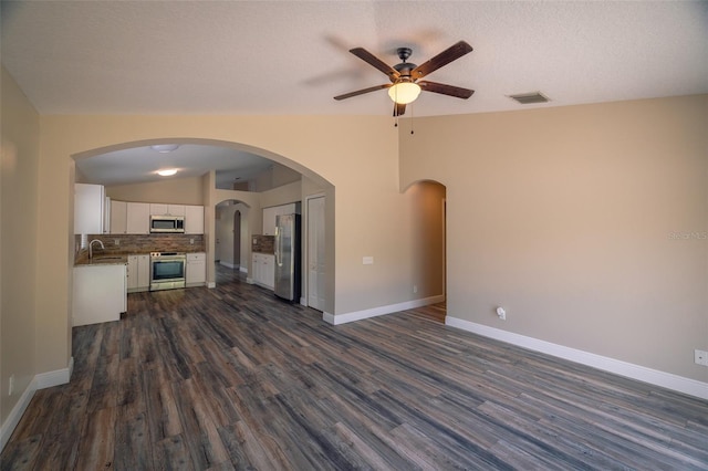 19247 Otters Wick Way, Land O Lakes, FL 34638 - unfurnished living room featuring a ceiling fan, a sink, dark wood-style floors, vaulted ceiling, and baseboards
